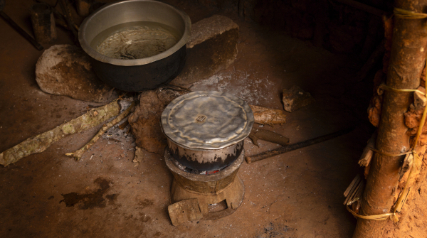 Imagem de um fogão a lenha em condições precárias, com uma panela sobre ele e uma outra panela maior ao lado. Foto: KucherAV/Getty Images via Canva.